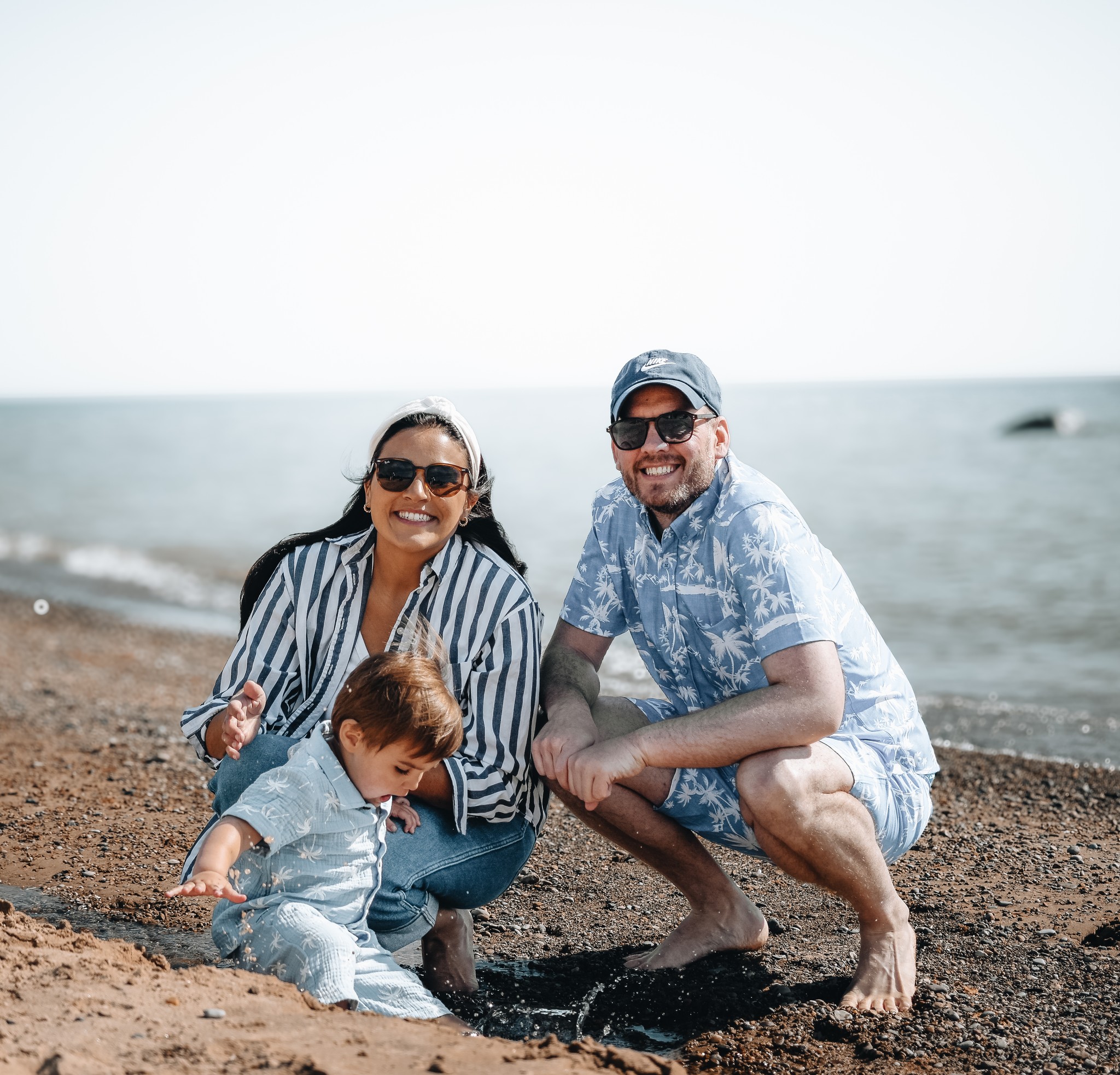 A family poses on a beach.