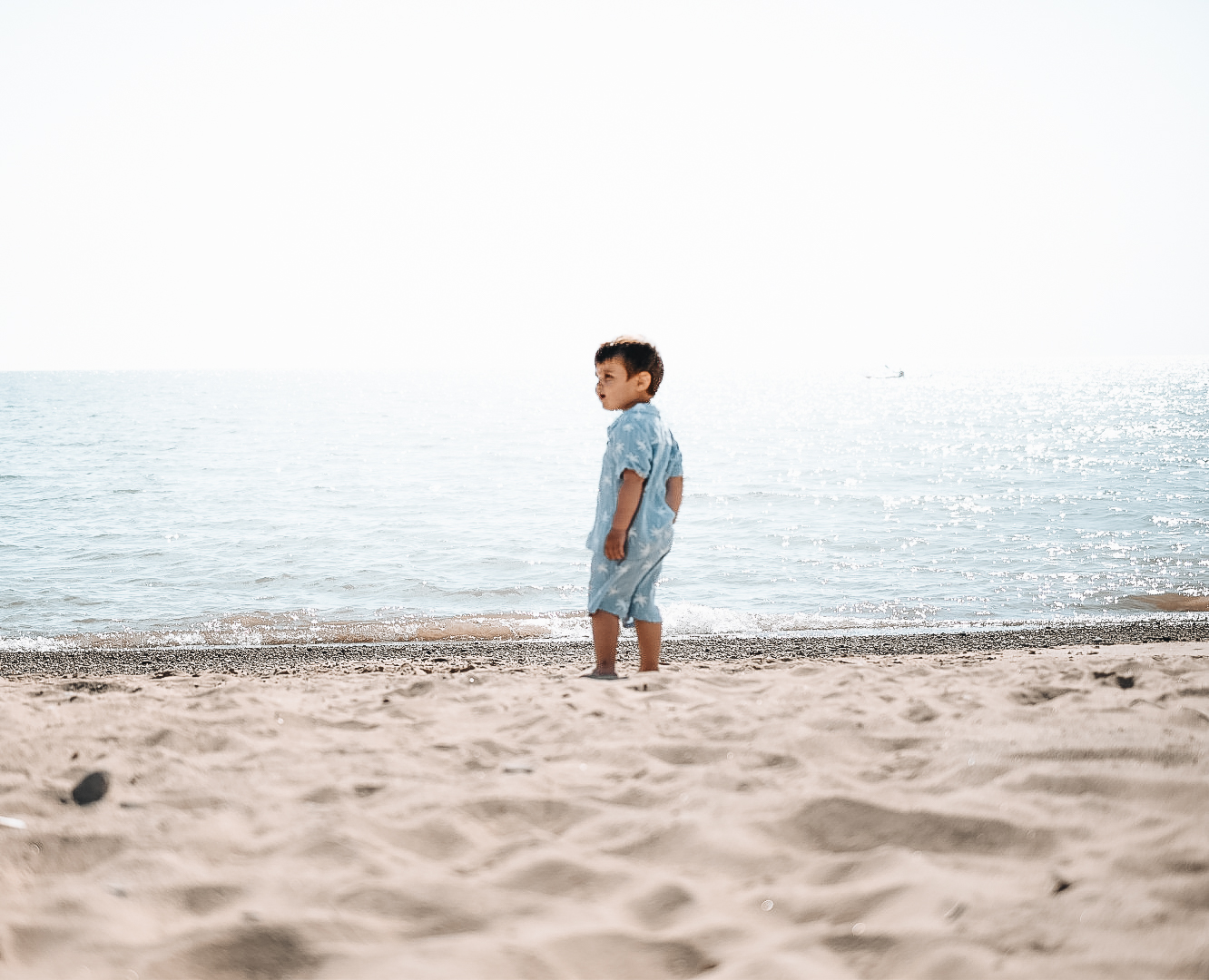 A child wanders near a lake.