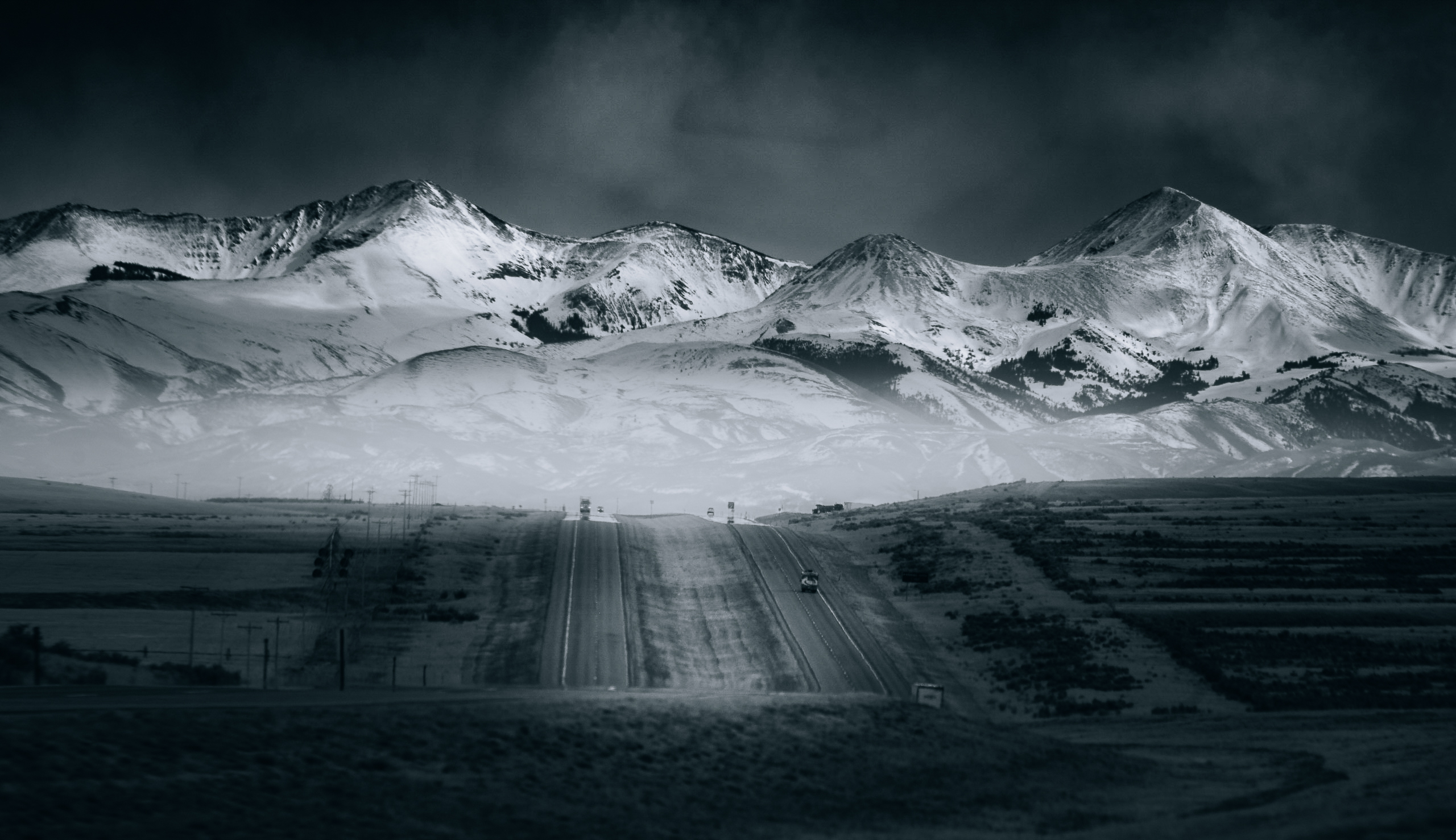 A black and white photo of Mountains out West from a vehicle.