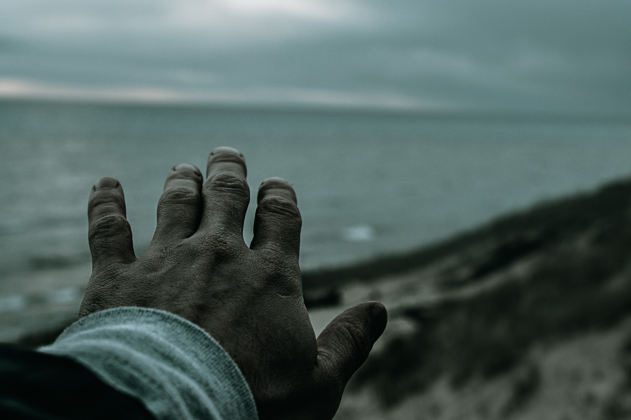 A man reaching his hand towards Lake Michigan