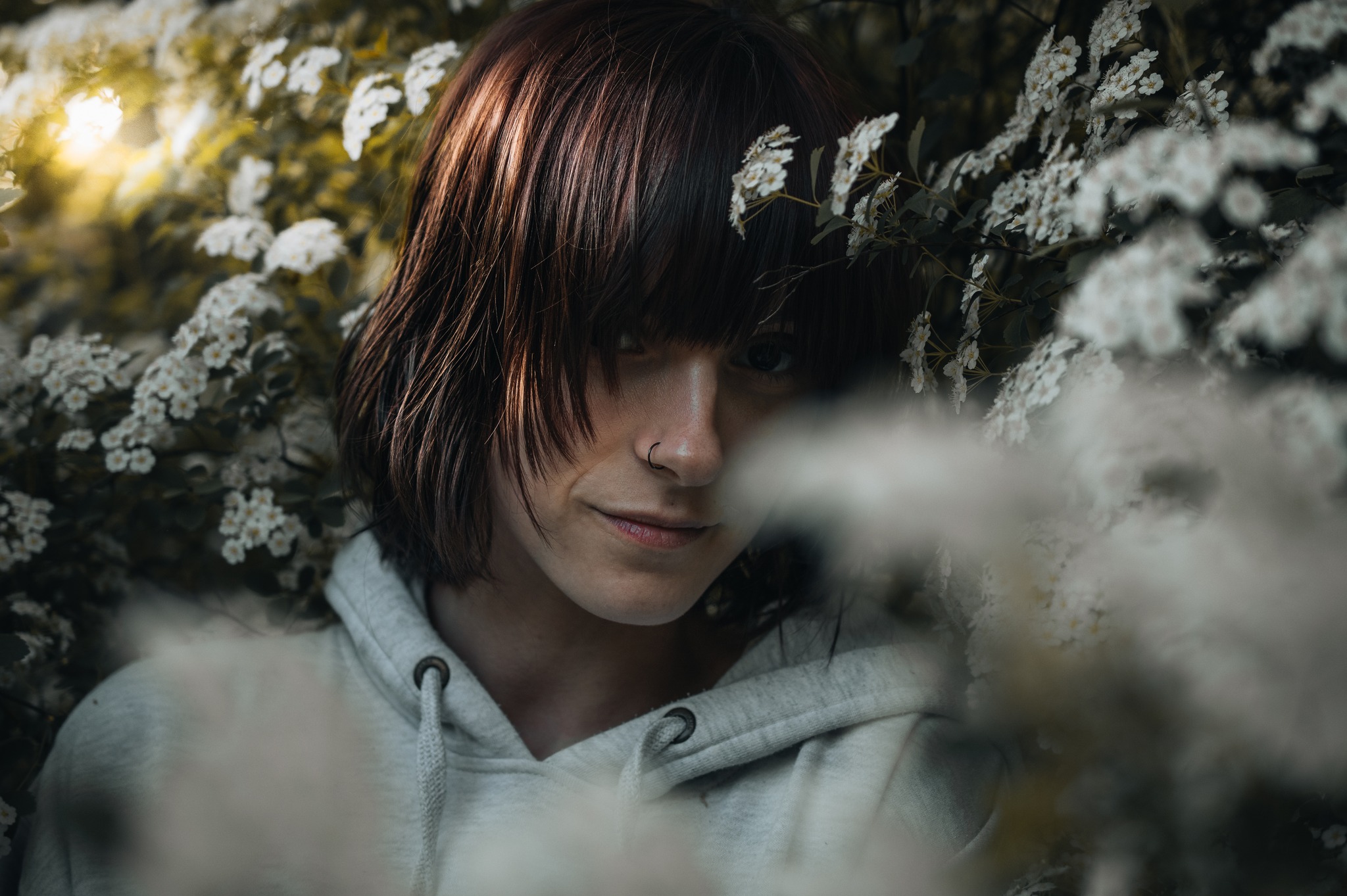 A portrait of a woman by flowers.