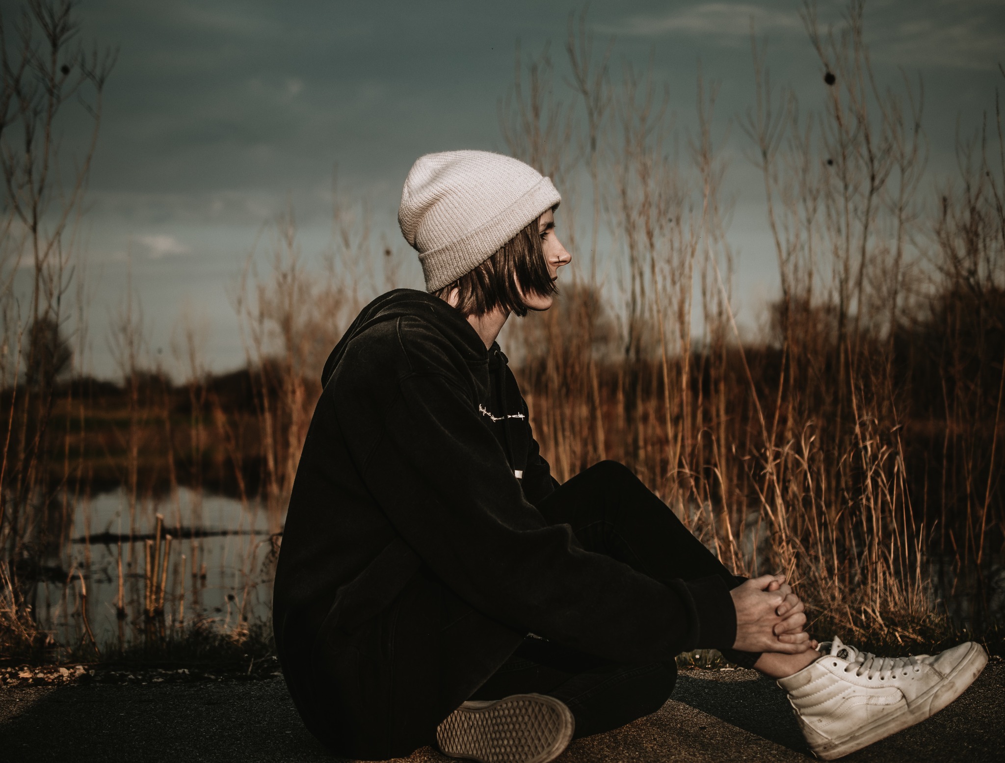 A portrait of a woman sitting down in nature.