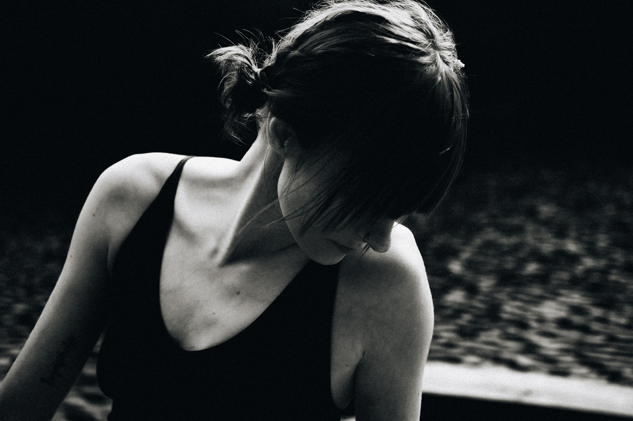 A portrait of a woman sitting down by a lake.