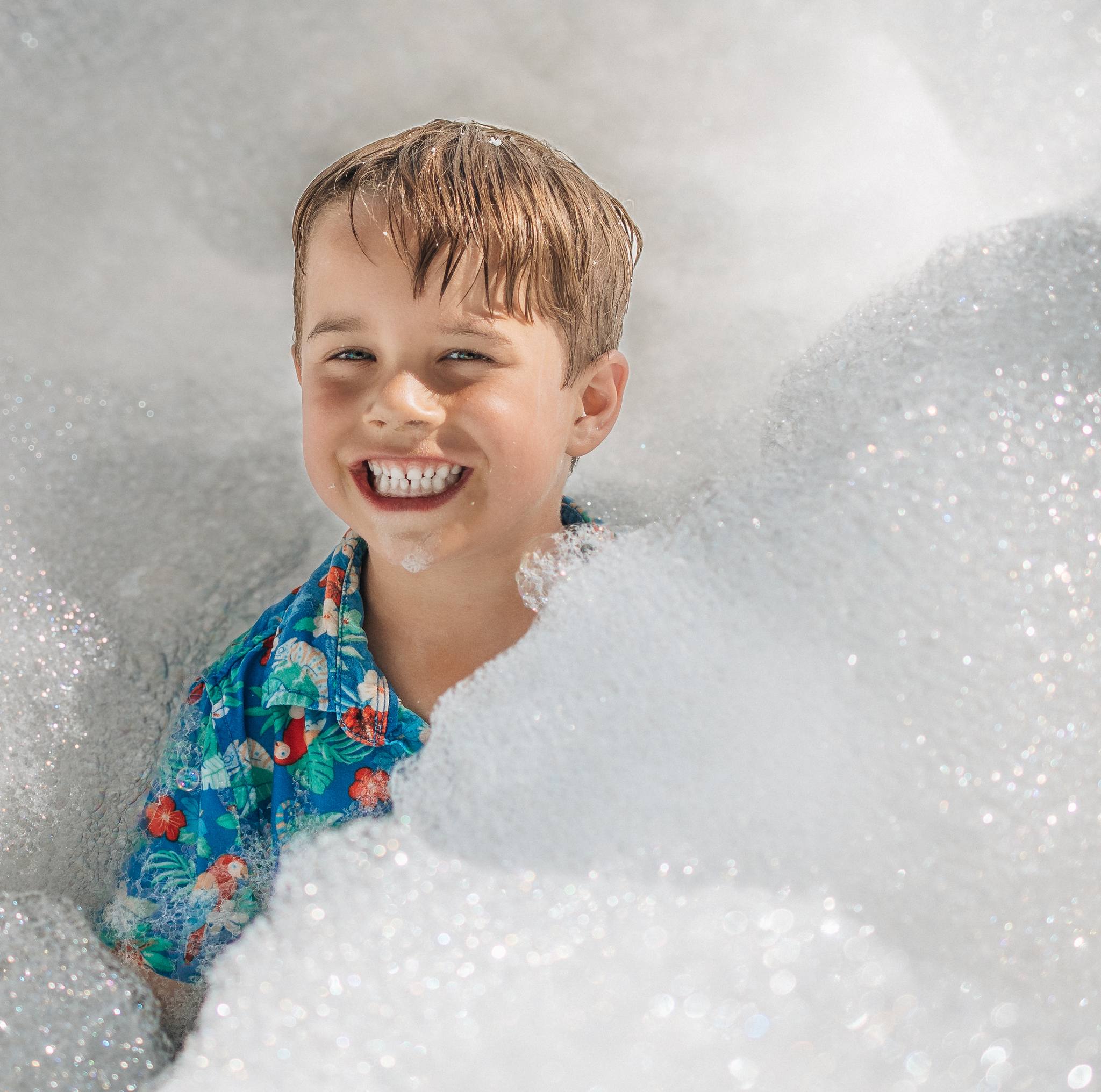 A portrait of a child playing in bubbles.